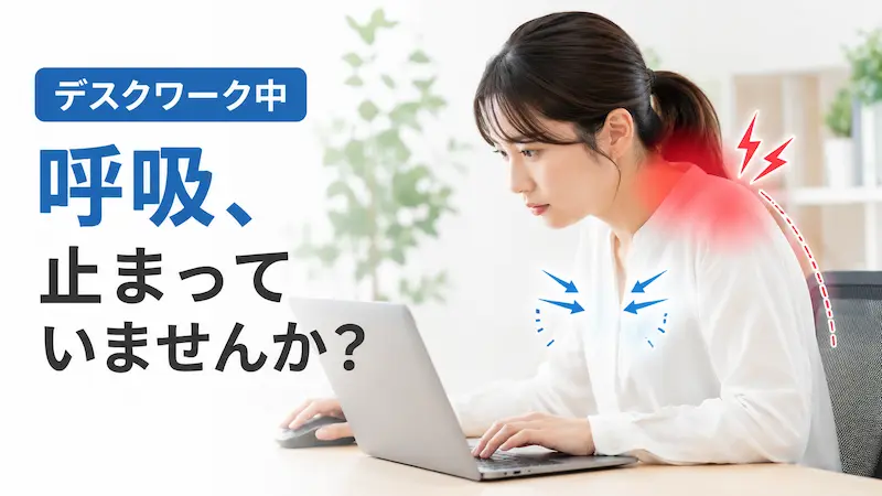 デスクワーク中に呼吸が浅くなり首肩に負担がかかる女性